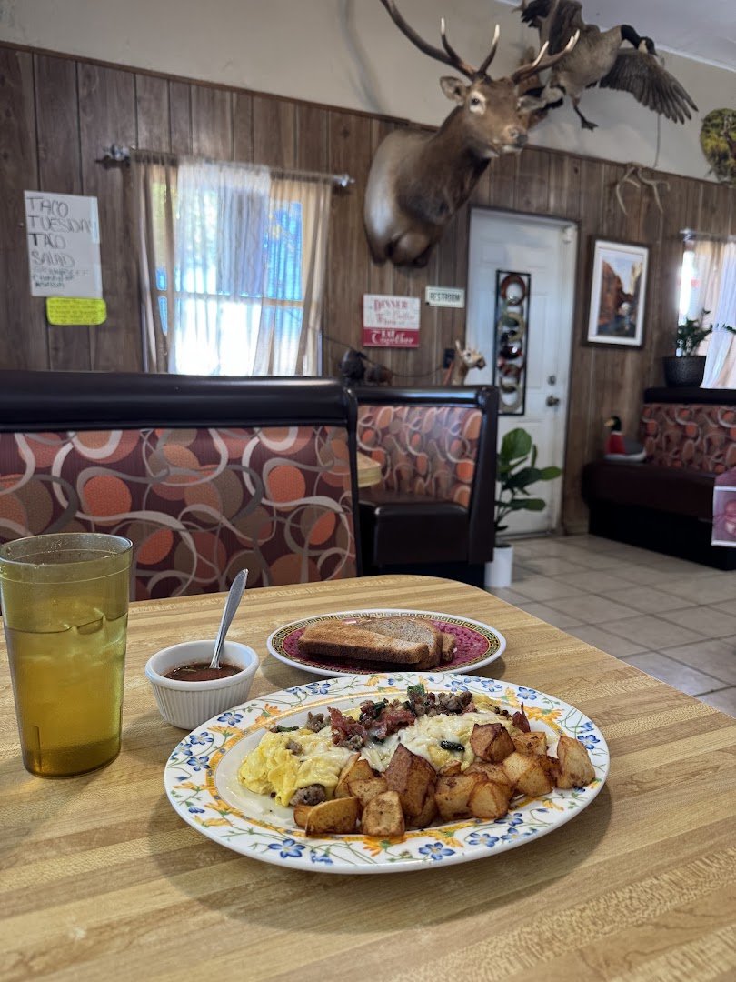 Coffee cups beside a plated breakfast.